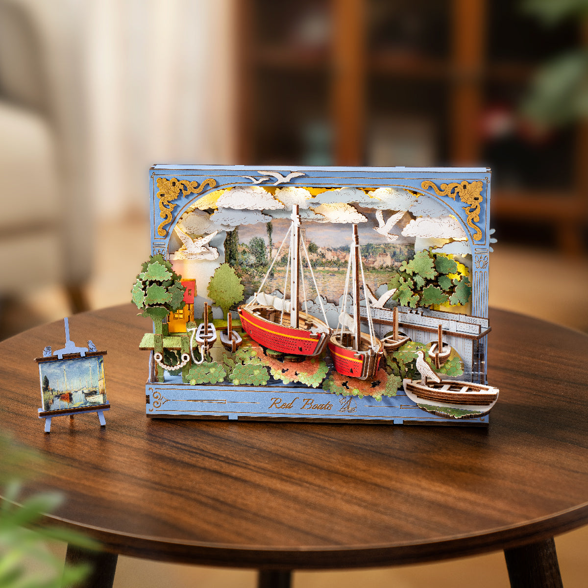 Rolife Red Boats 3D art frame displayed upright on a round wooden coffee table in a bright living room