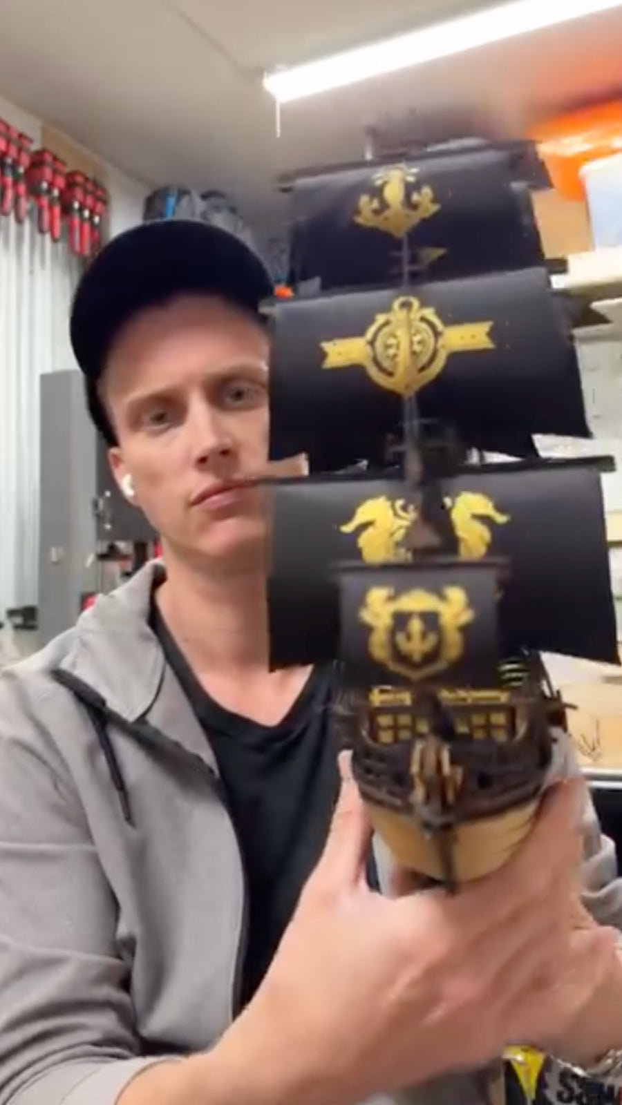 Man holding a tall black wooden mechanism decorated with gold emblems and a winged crest