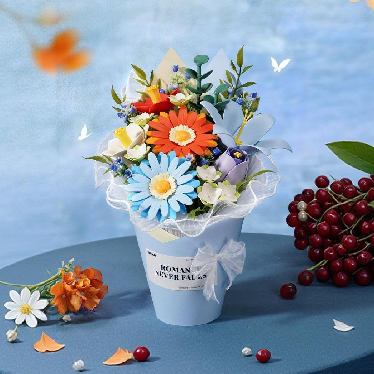 Rolife Romance Never Fades mini flower bouquet in white pot with blue daisies, orange flowers and red berries on soft blue backdrop