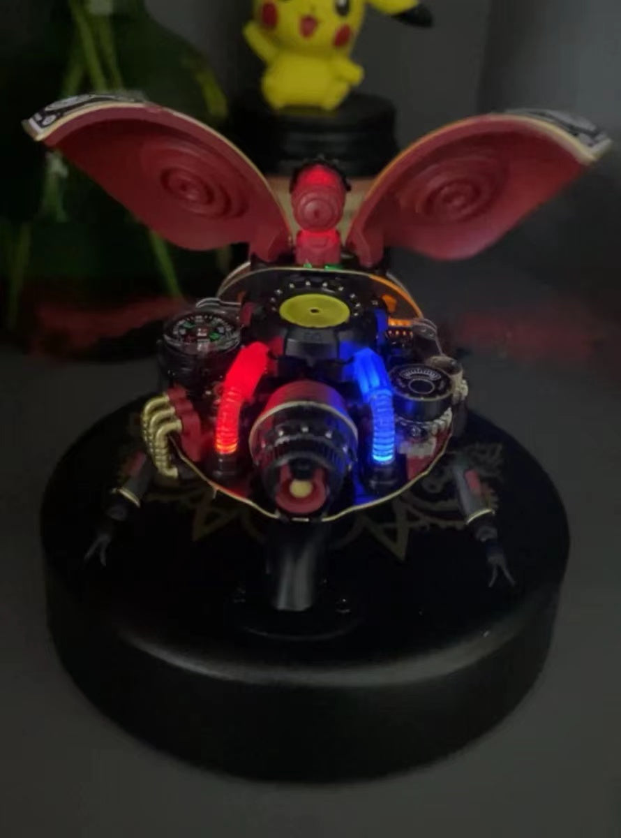 ROKR Scout Beetle MI02 with spread pink wings and red and blue LED illumination on a dark display base