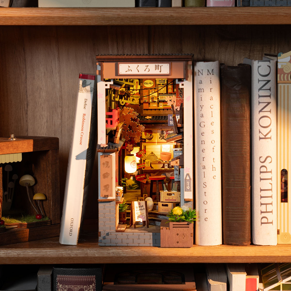 Rolife Sakura Wine Alley Bücherecke TGB11 Lifestyle-Szene auf einem Schreibtisch mit Büchern, warm leuchtender japanischer Straßenszene und Miniaturfiguren