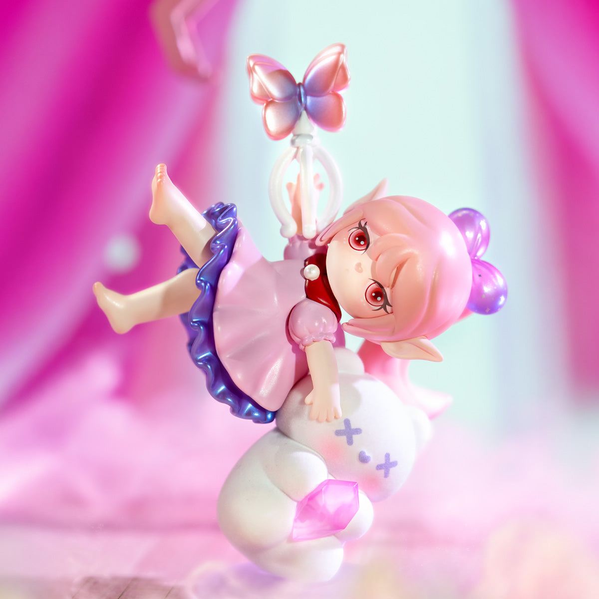 Rolife Suri's Colorful Girls SKXX pink elf doll tumbling mid-air in a pink frilly dress holding a butterfly wand, riding a white creature on a soft pink dreamy background