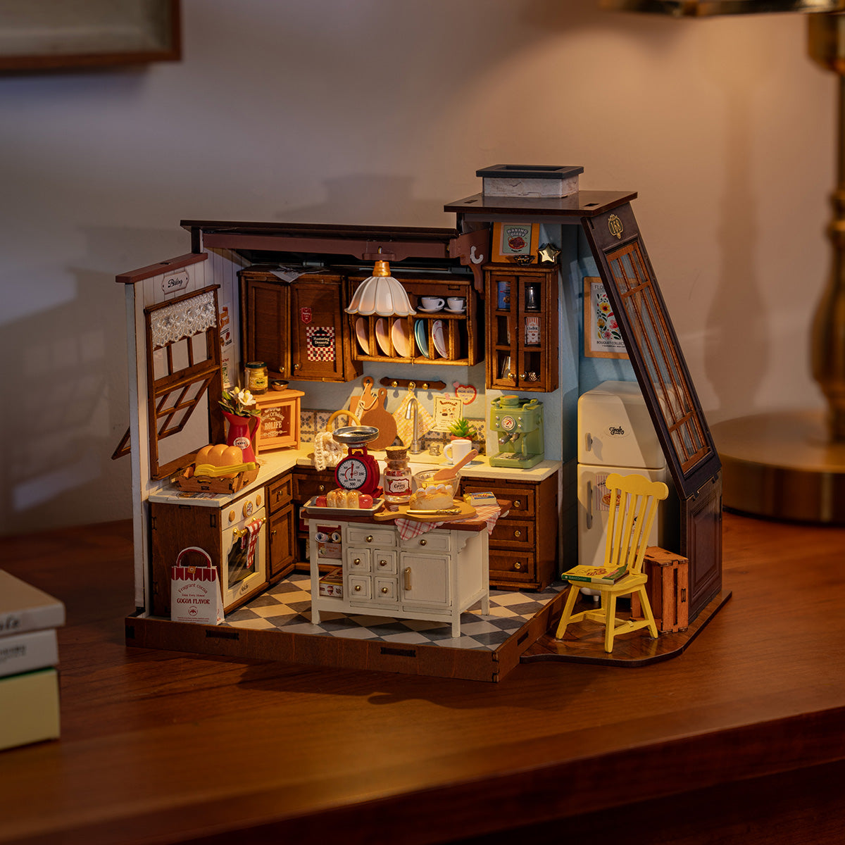 Rolife Baking Kitchen DIY Miniature House DG172 assembled and lit with warm golden light showing the full kitchen interior including checkerboard floor yellow chair and all furnishings