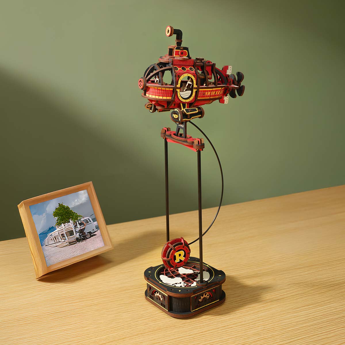 ROKR Deep-Sea Adventurer Gravity Swing MCD04 red submarine and ROKR Road Tripper MCD03 orange car pendulum toys displayed together on wooden desk with lifestyle props