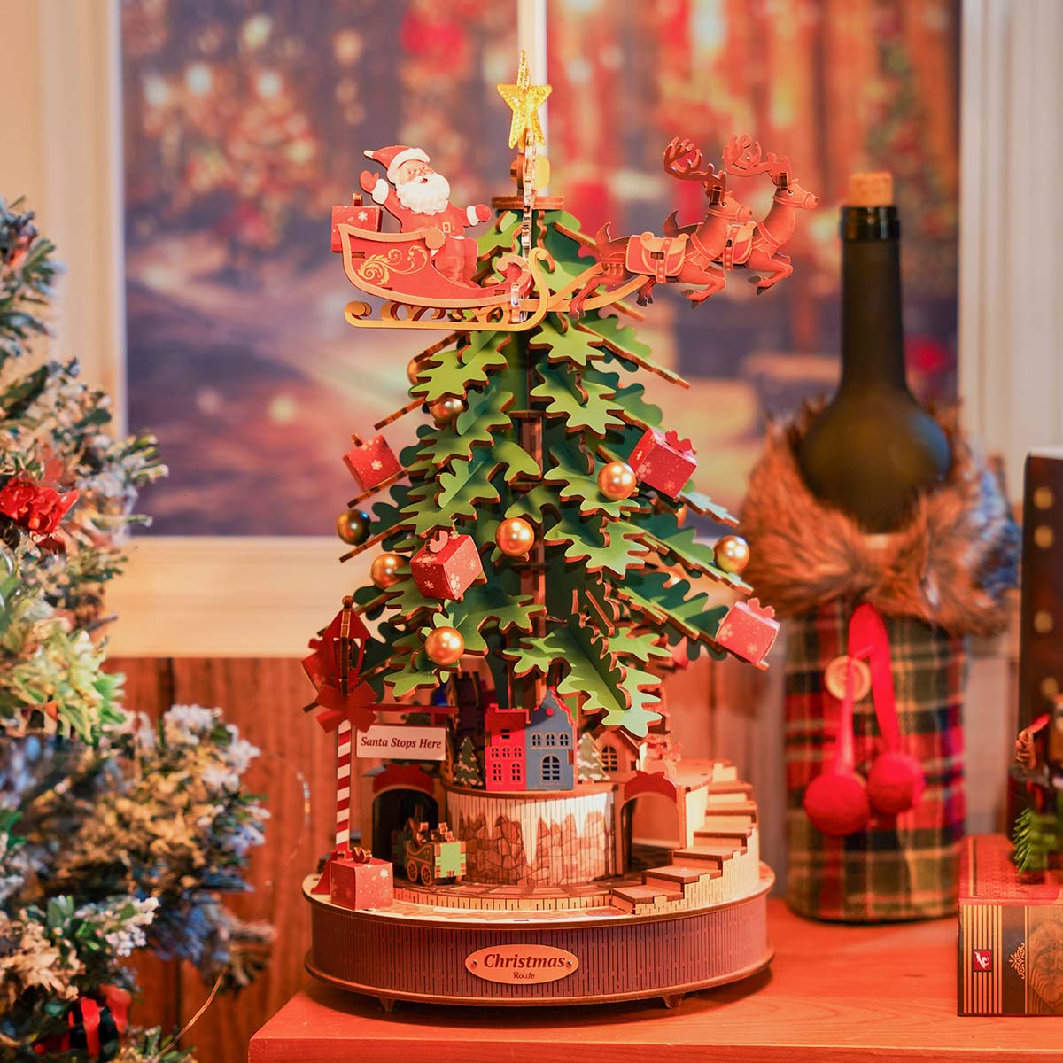 Rolife Christmas tree music box glows with red ornaments, warm lights, and a tiny house base.