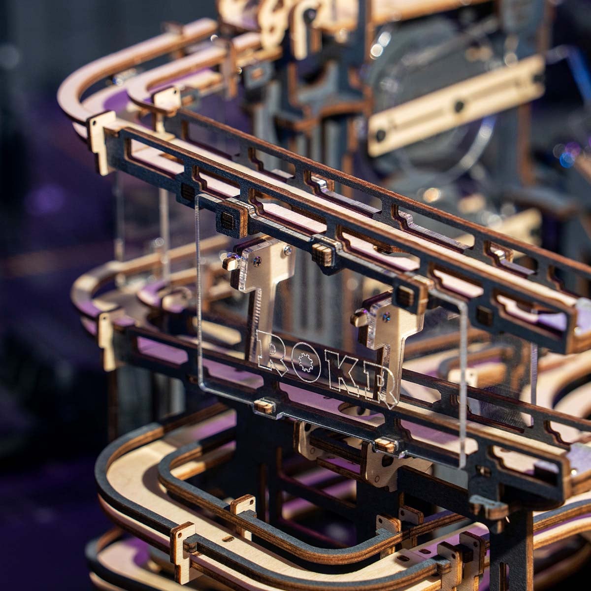 Extreme close-up of ROKR Marble Night City curved rail channels and elevator column under dramatic purple-toned lighting