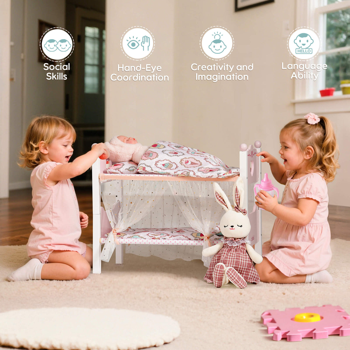 Two toddler girls play together with the ROBUD pink wooden doll bunk bed, placing a baby doll and a bunny plush inside with delight
