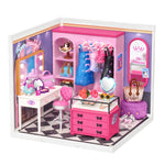 Miniature pink and purple dressing room with vanity table, heart-shaped stool, clothing rack, pink drawers and checkered floor.