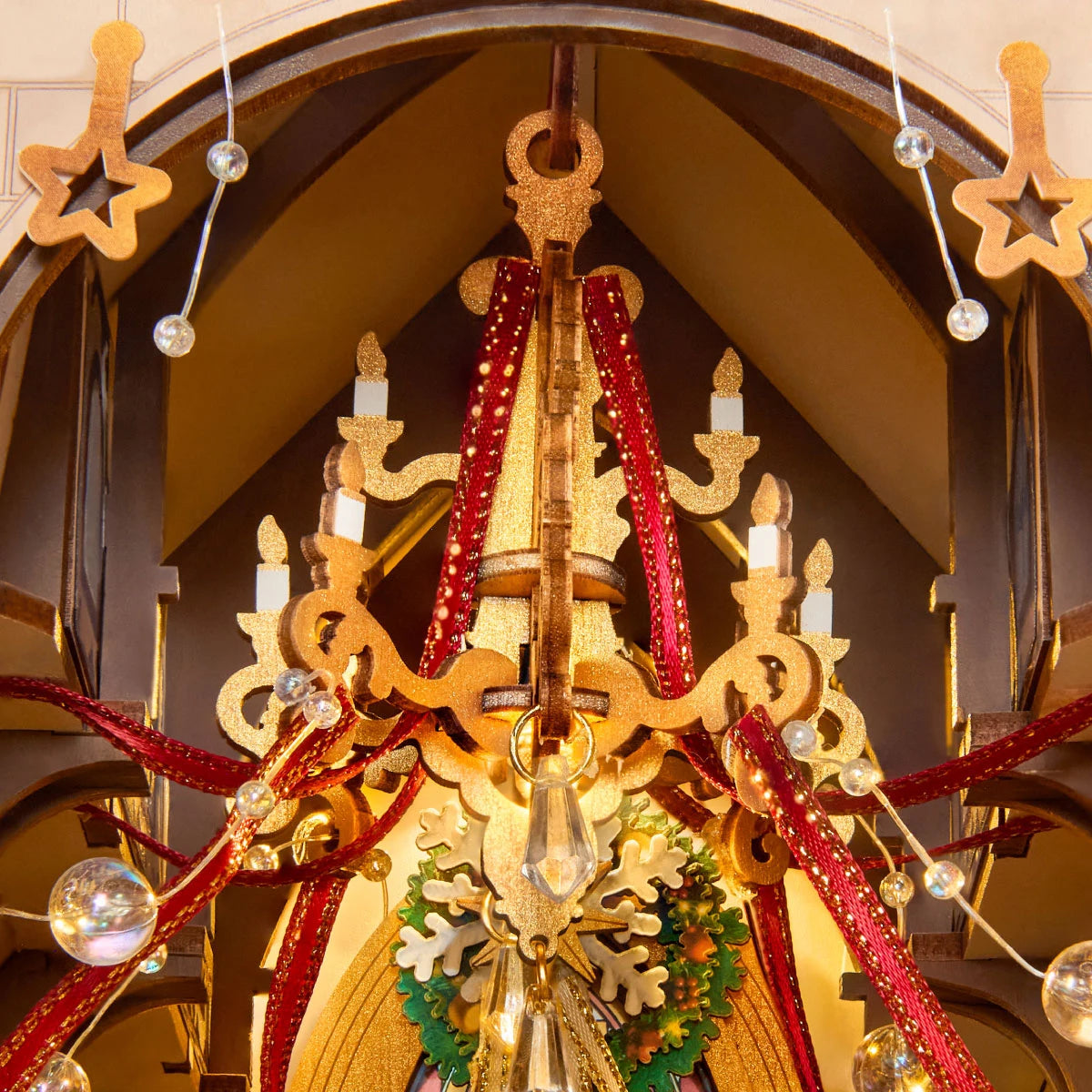 Goldener Kronleuchter mit Kerzendetails, klaren Perlen, roten Schleifen und Kranz in Rolife Caroling Cathedral
