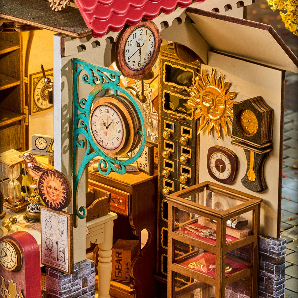 Close-up of Rolife miniature clock shop interior showing a blue ornate wall clock, sun face ornament, wooden display case and tiny clock accessories.