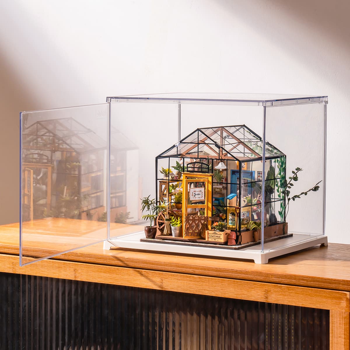 Rolife Cathy's Flower House display box sits on a wooden cabinet with a softly lit room behind it.