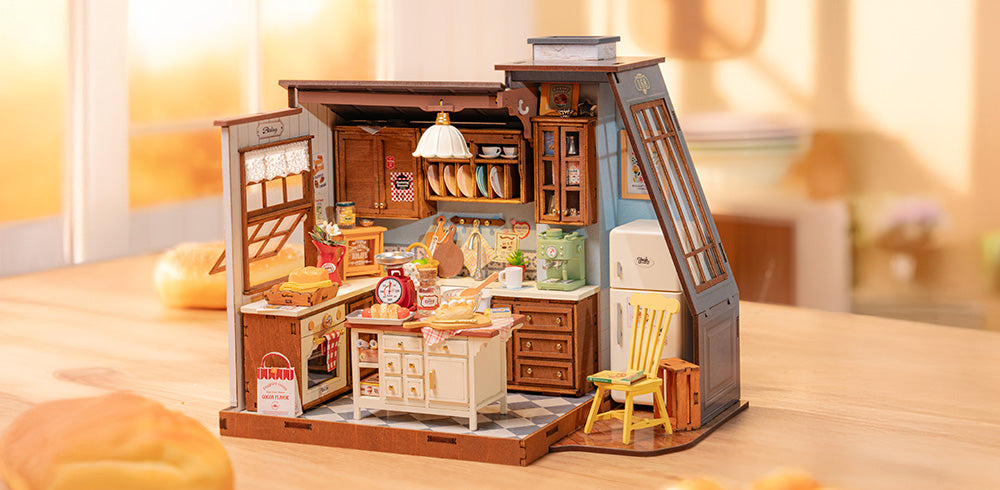 Robotime Online DG172 PC banner showing the Rolife miniature bakery DIY house in a wide warm-toned lifestyle scene with bread props