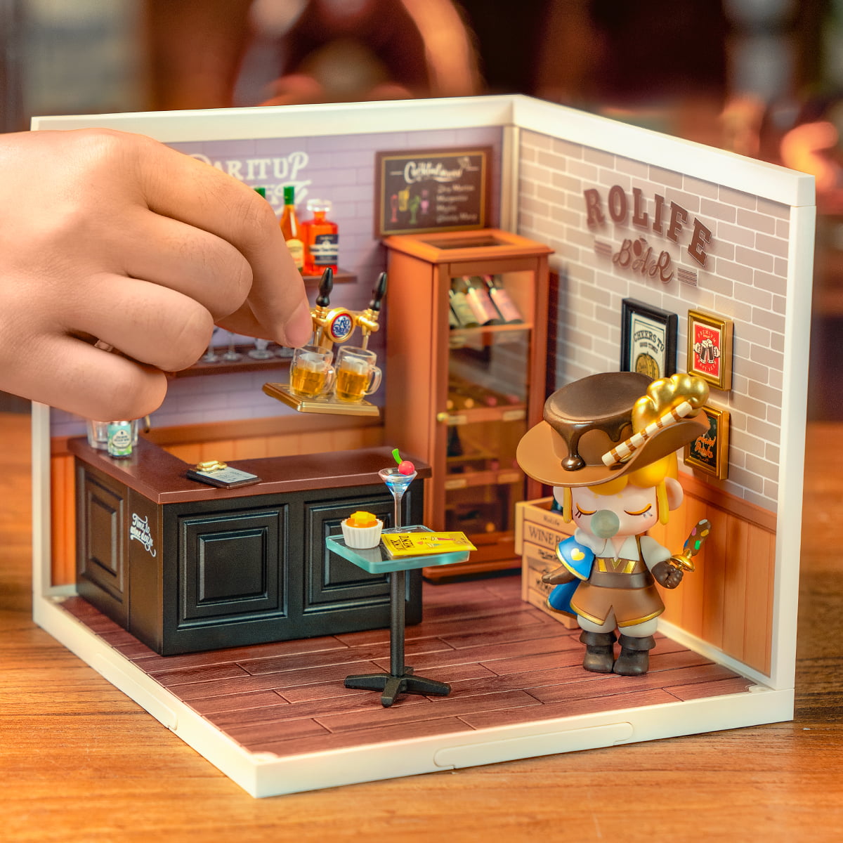 Rolife Leisurely Cheers Bar DW012 Super Creator miniature room with character figurine placing beer mug on counter showing fun assembly interaction
