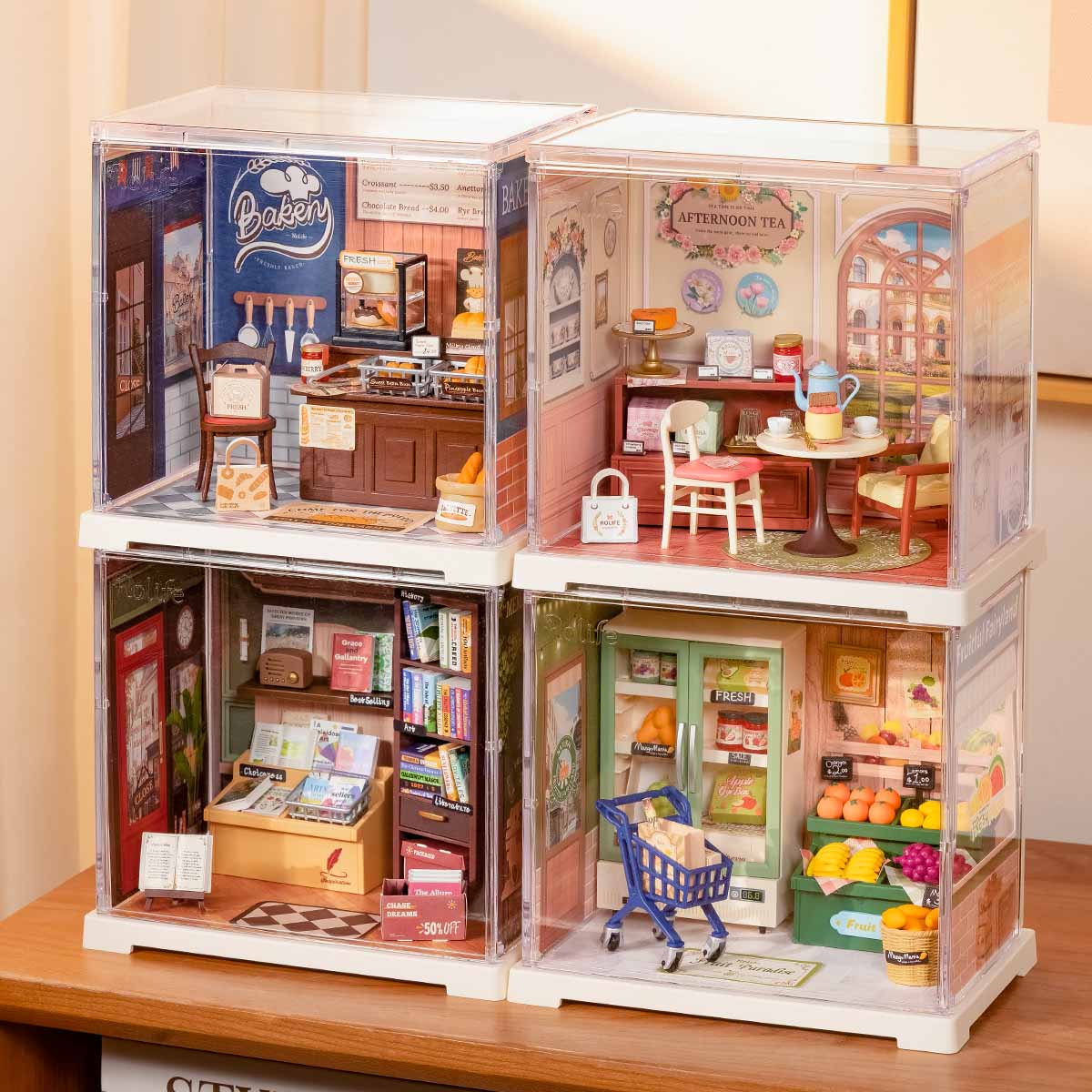 Rolife Memory Book Store Super Creator Mini four-set stacked display showing Bakery, Afternoon Tea, Book Store and Seasonal Fruits arranged in 2x2 formation on a table.