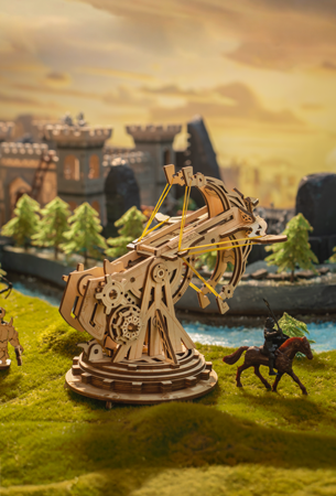Robotime Epic War collection theme graphic showing ROKR wooden trebuchet siege engine model against fantasy castle landscape