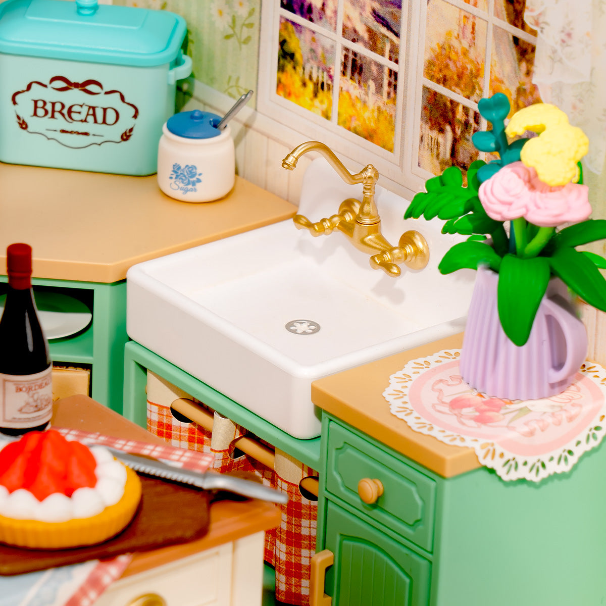 Rolife Farmhouse Kitchen DW024 close-up of a mint green kitchen counter with a gold tap, white farmhouse sink, and a vase of pink and yellow flowers