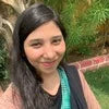 Headshot of blog author Ifrah Rizwan Farooqi smiling outdoors among green foliage in a casual setting.