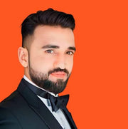 Robotime blog author Irfan Sajid headshot portrait in black formal suit against bright orange background for contributor