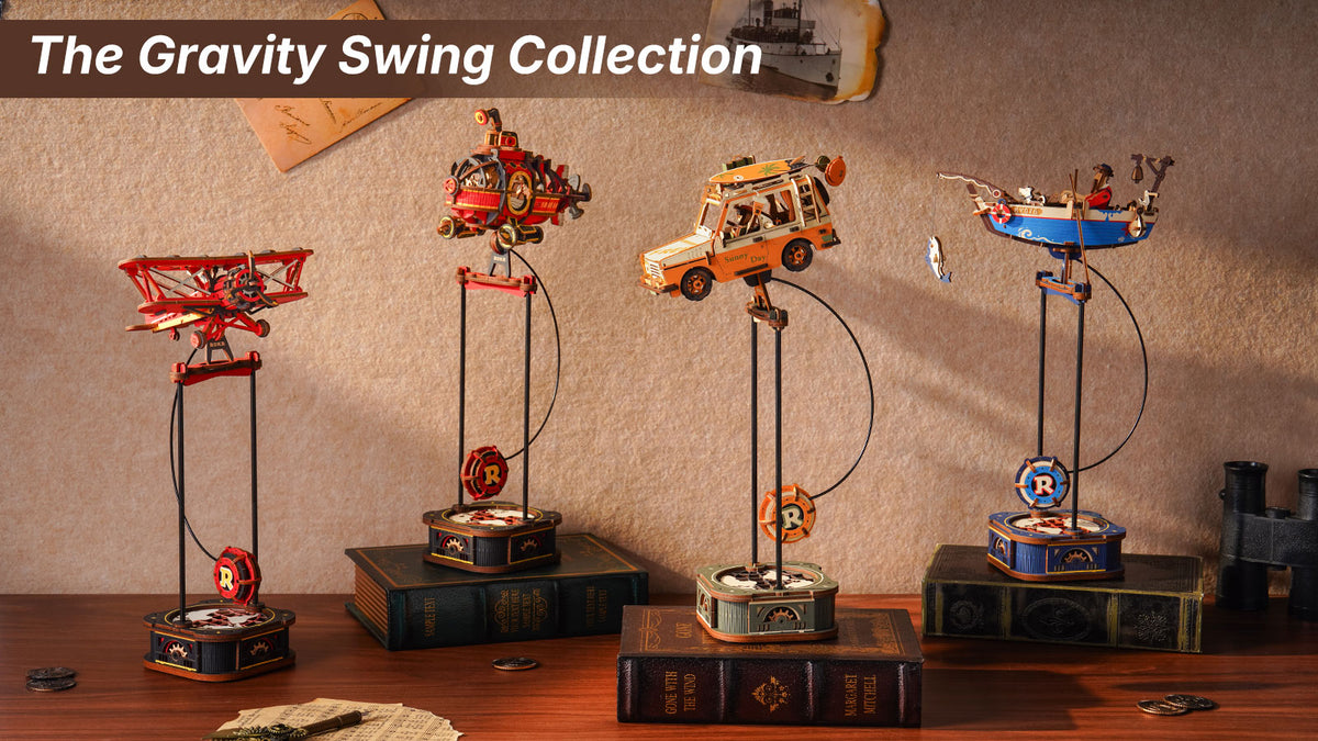 ROKR Gravity Swing collection banner showing four pendulum toys including biplane, steampunk airship, road-trip SUV, and fishing boat on stacked books