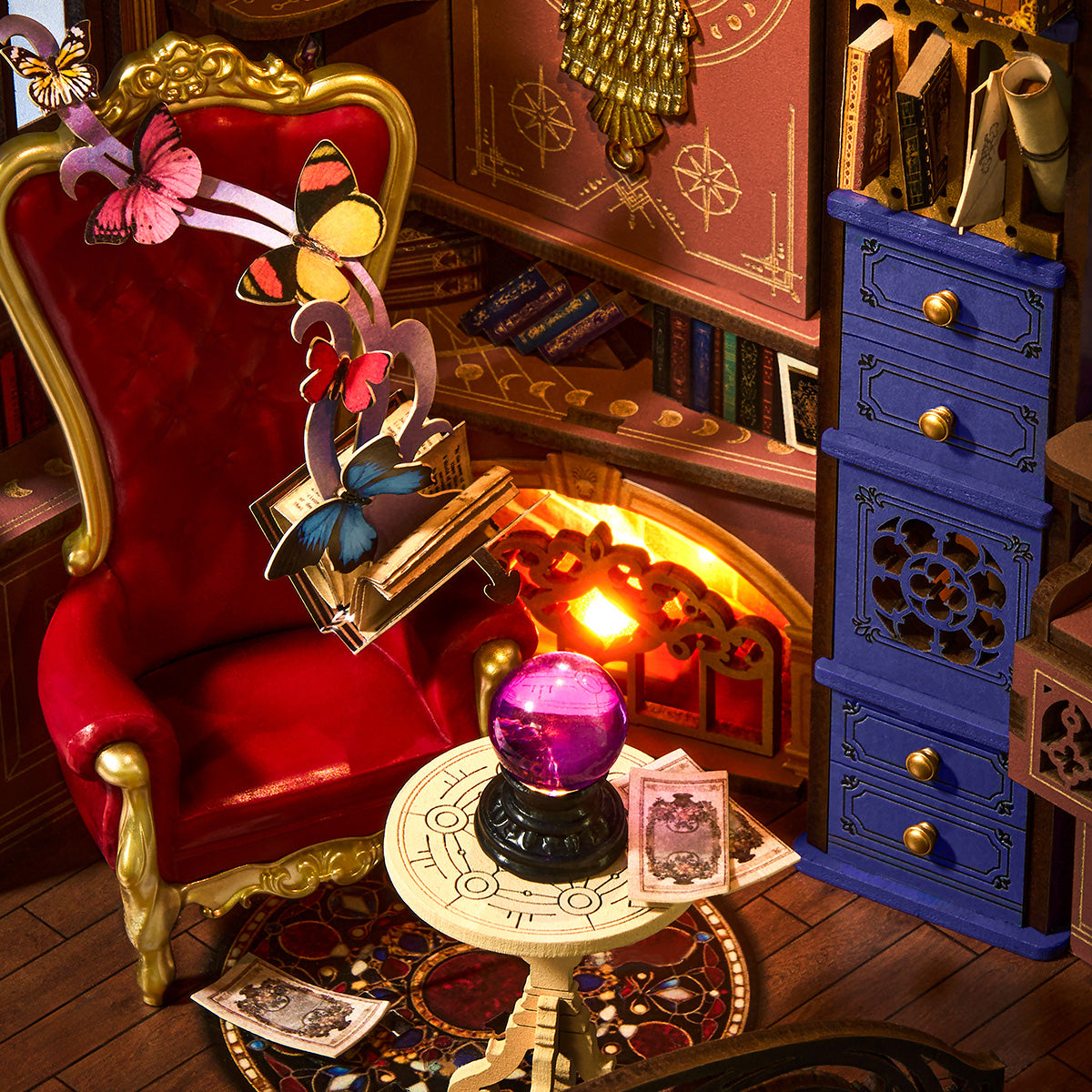 Rolife Magic Fantasy Corner TGB14 close-up of red velvet high-back chair, glowing purple crystal ball, tarot cards, and fireplace with butterflies