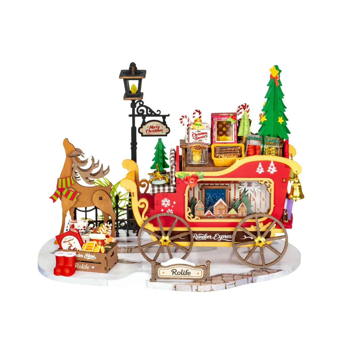 Rolife wooden reindeer and red sleigh miniature on a white base with a lamp post, Christmas tree, gifts, candy, and a Rolife sign.