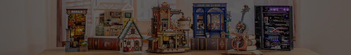 Robotime blog desktop banner showing a wide lineup of Rolife miniature houses, book nooks, and ROKR wooden puzzles displayed on a table