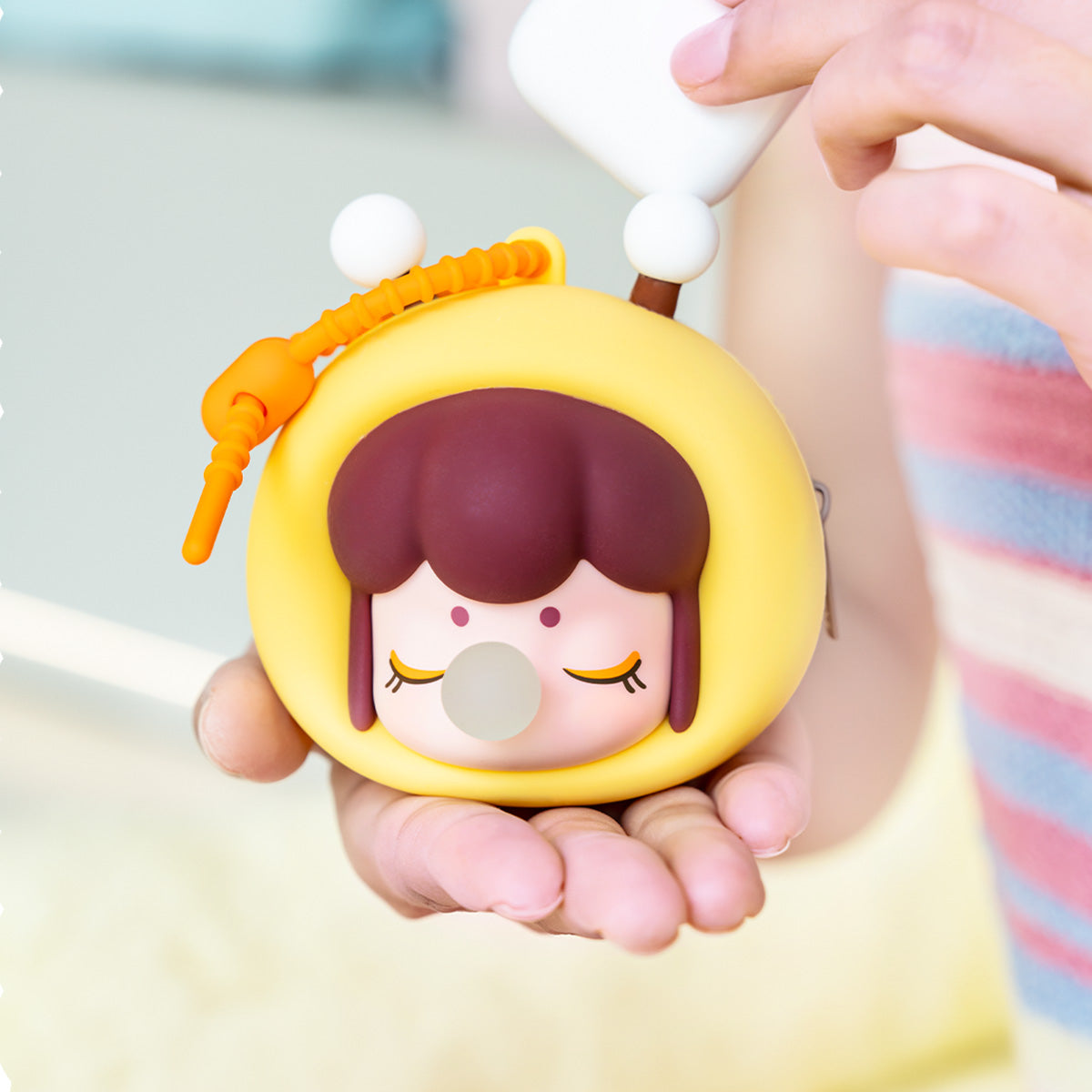 Rolife Baby Nanci Fluffy Party Headphone Case Bee variant close-up showing yellow rounded body, bee antenna topper, and orange braided phone strap