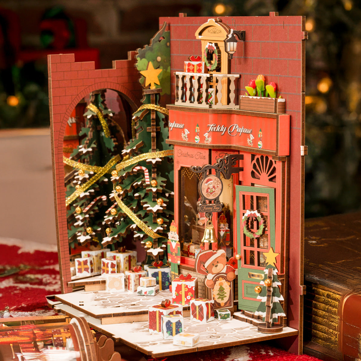 Rolife Christmas Indoor Scene book nook showing a red Teddy Playhouse facade with Christmas tree, gift boxes, bell, and teddy bear figure.