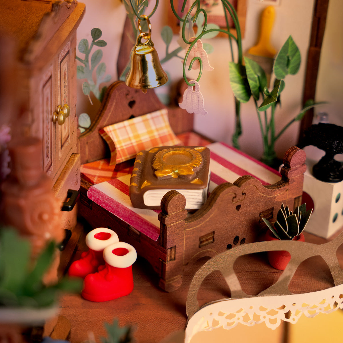 Hände beim Zusammenbau des Rolife Fairytale Tree House DG179, das eine dekorative Holzschubladeneinheit mit Miniaturzubehör und Anleitung auf einer hellgrünen Oberfläche montiert