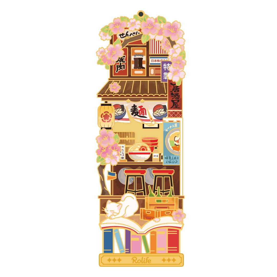 Tall Rolife street shop miniature framed by pink blossoms and pastel storefronts