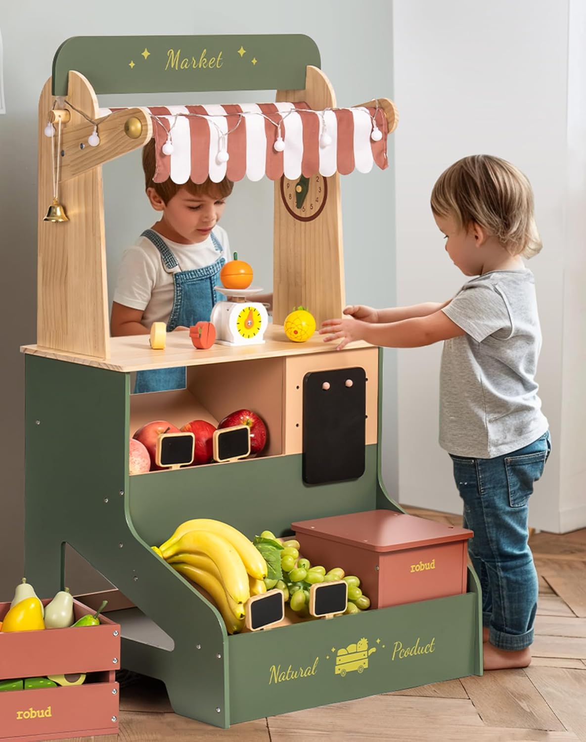 Robud wooden grocery market stand with green canopy, a toddler reaching for bananas and colourful produce