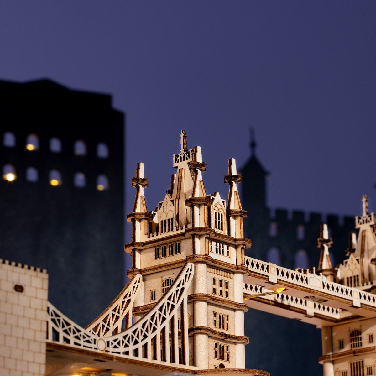 Rolife Tower Bridge model tower close-up at dusk showing Gothic arches and crenellations against a deep blue city skyline