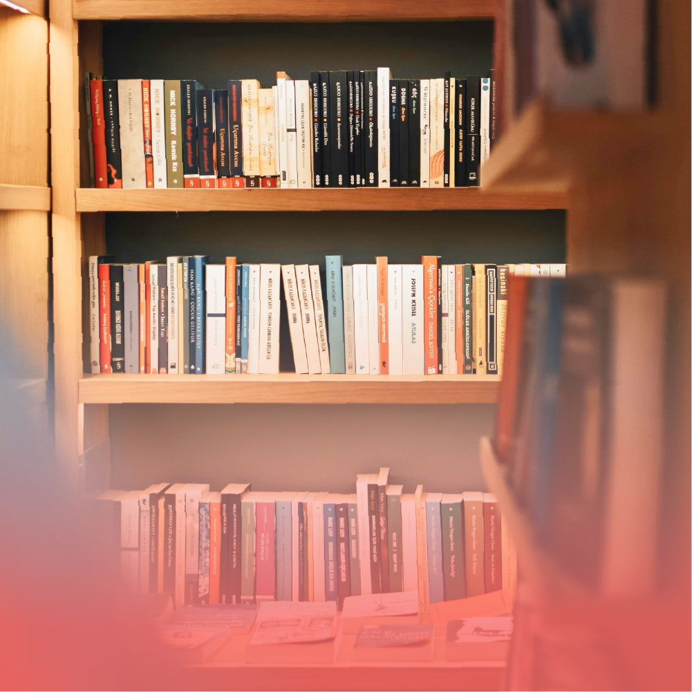 Wooden bookshelf with two rows of books in warm indoor lighting, a lifestyle background for Robotime book nook category.