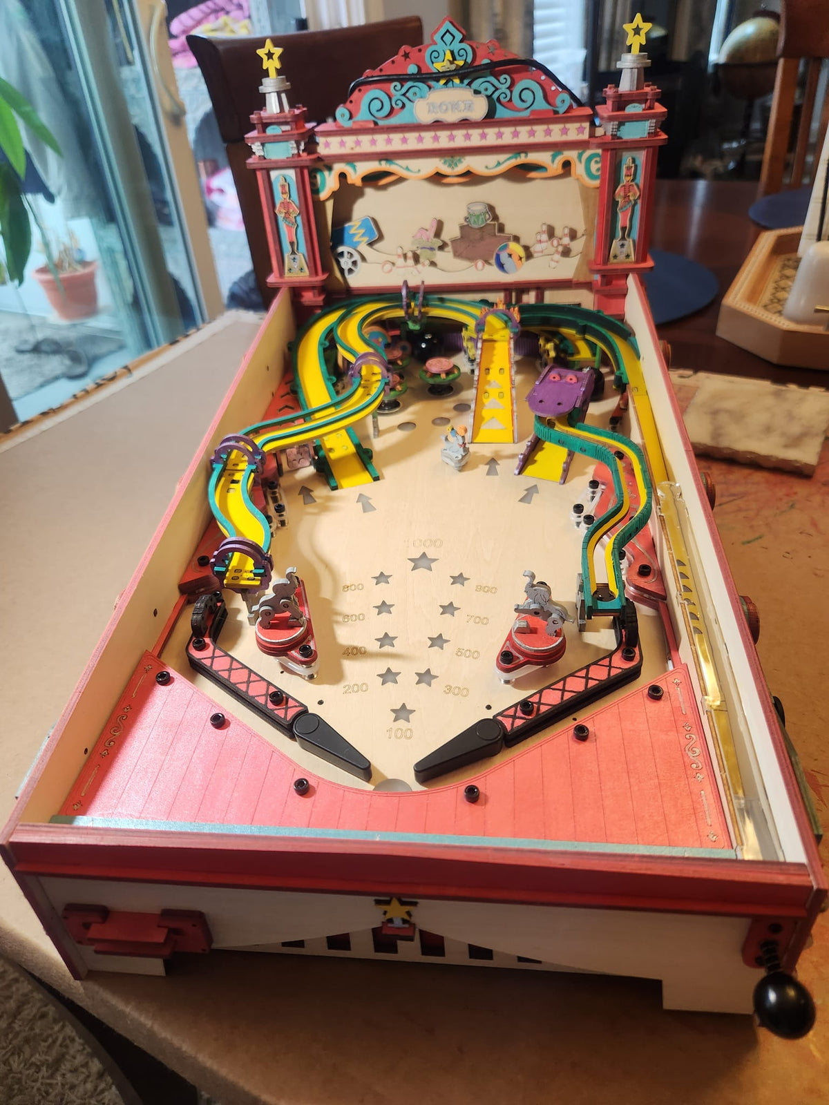 Robotime pink pinball table has a white playfield, bright bumpers, and ornate trim.
