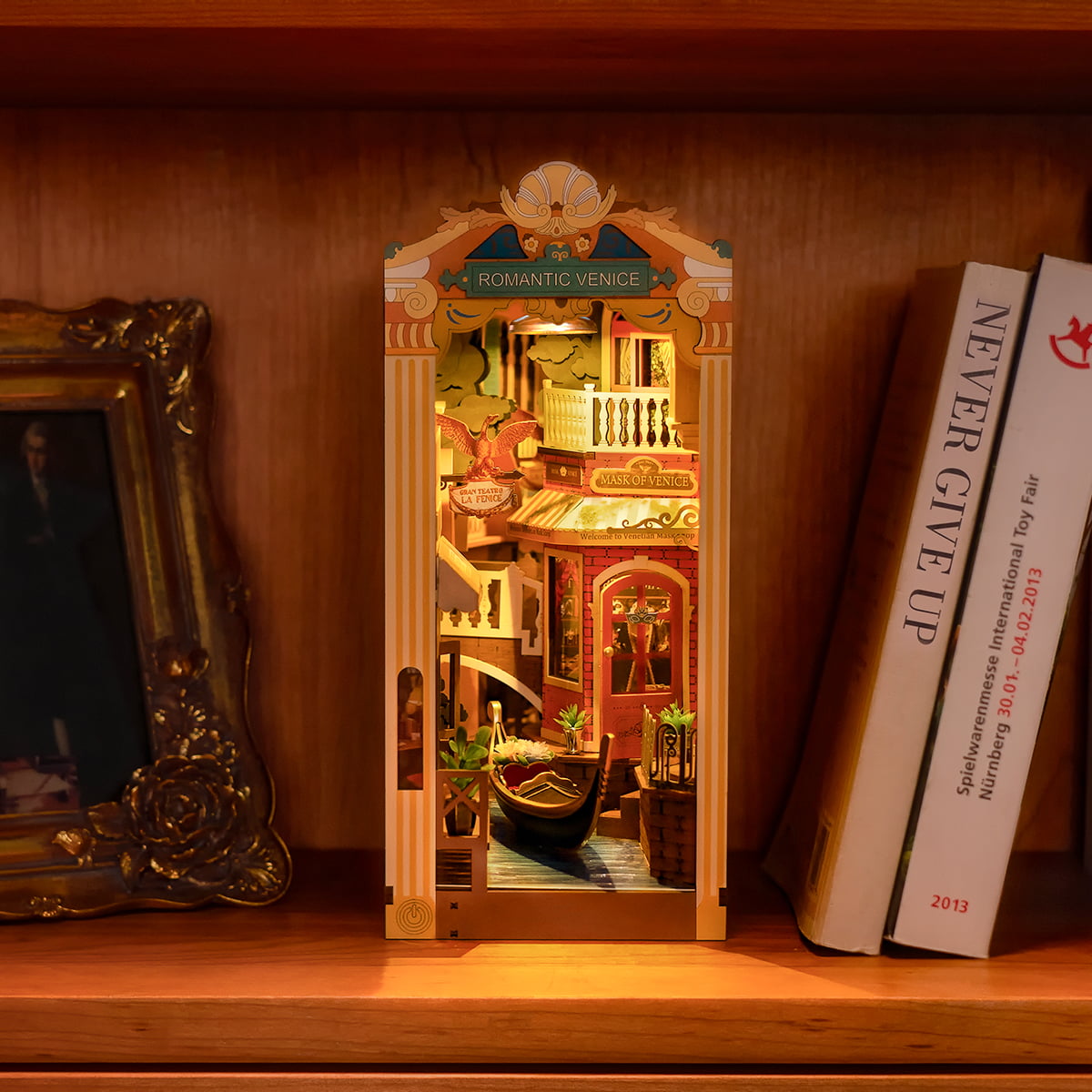 Rolife Sunshine Town DIY book nook displayed on wooden bookshelf beside picture frame and book spines