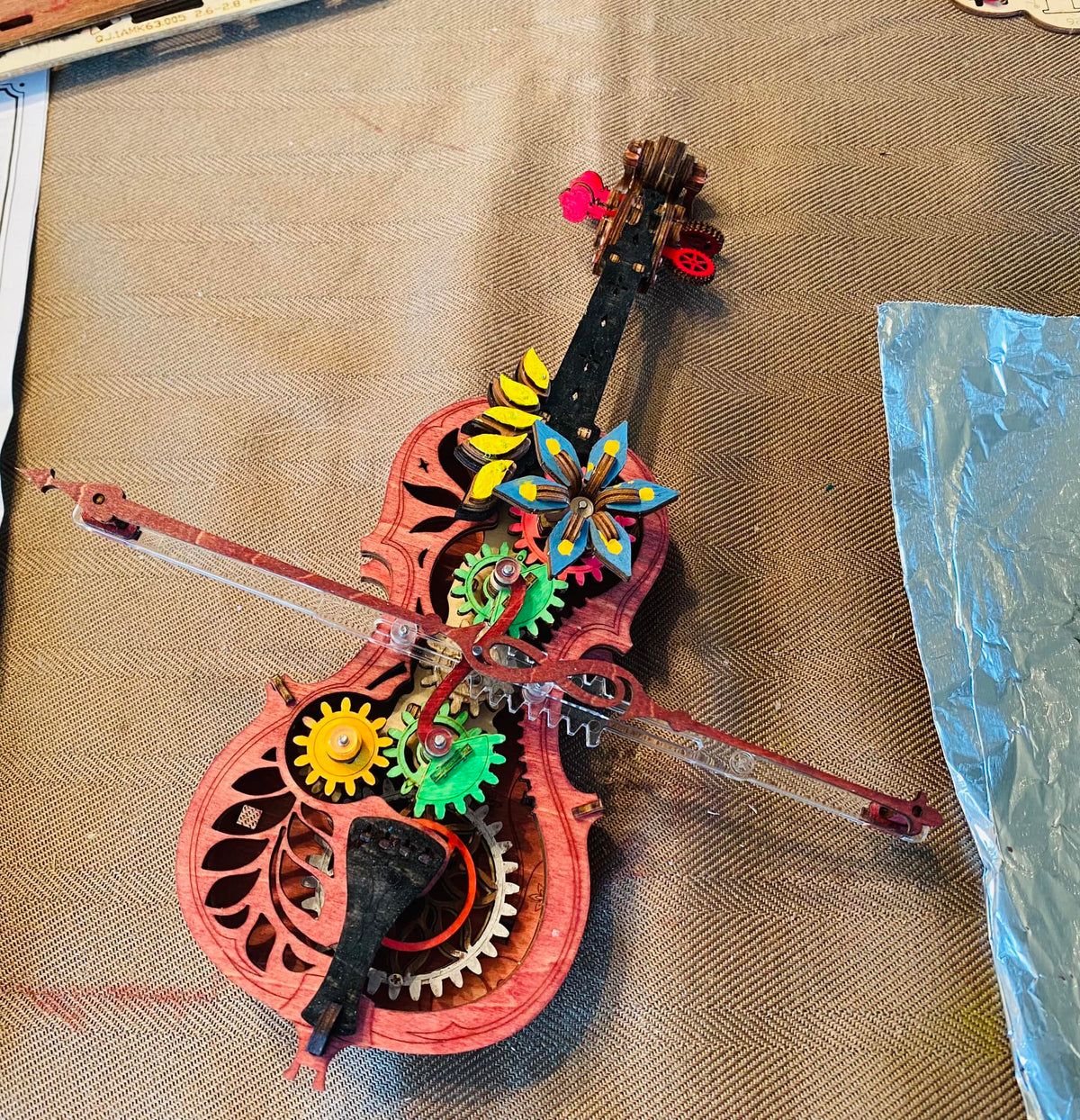 Robotime colorful violin music box shows gears, bow pieces, and floral accents.