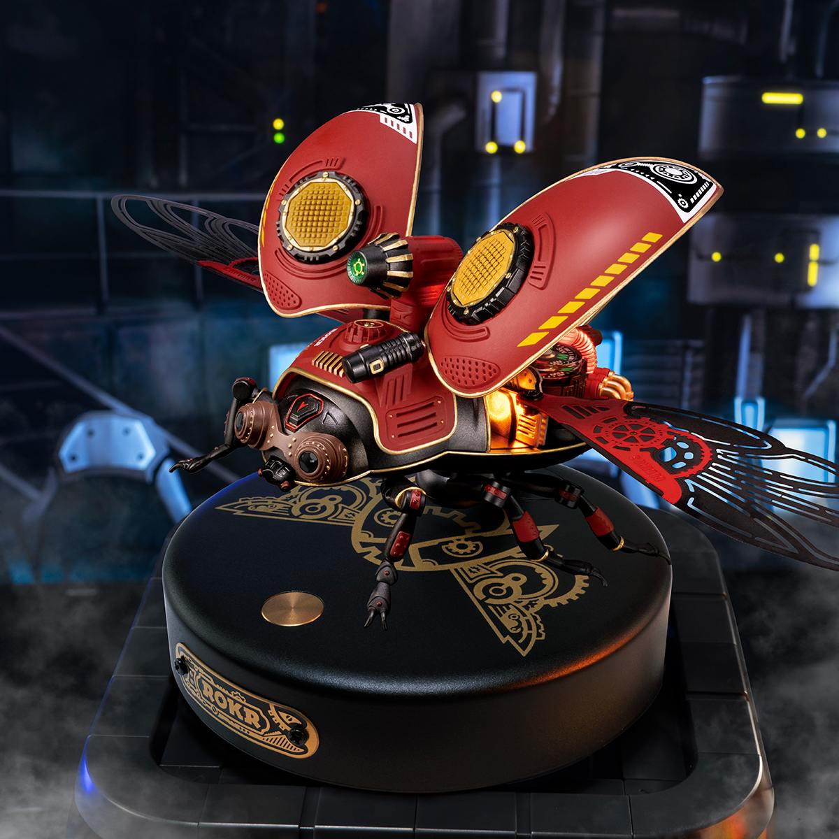 ROKR Scout Beetle mechanical 3D puzzle assembled on a dark base with red wings spread under moody blue lighting