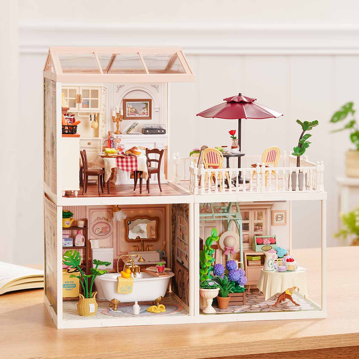 Rolife Super Creator Series 3-in-1 L Shape miniature showing a bedroom and yellow kitchen with swing rooftop next to a living room plus bathroom in a two-piece L arrangement on a wooden surface.