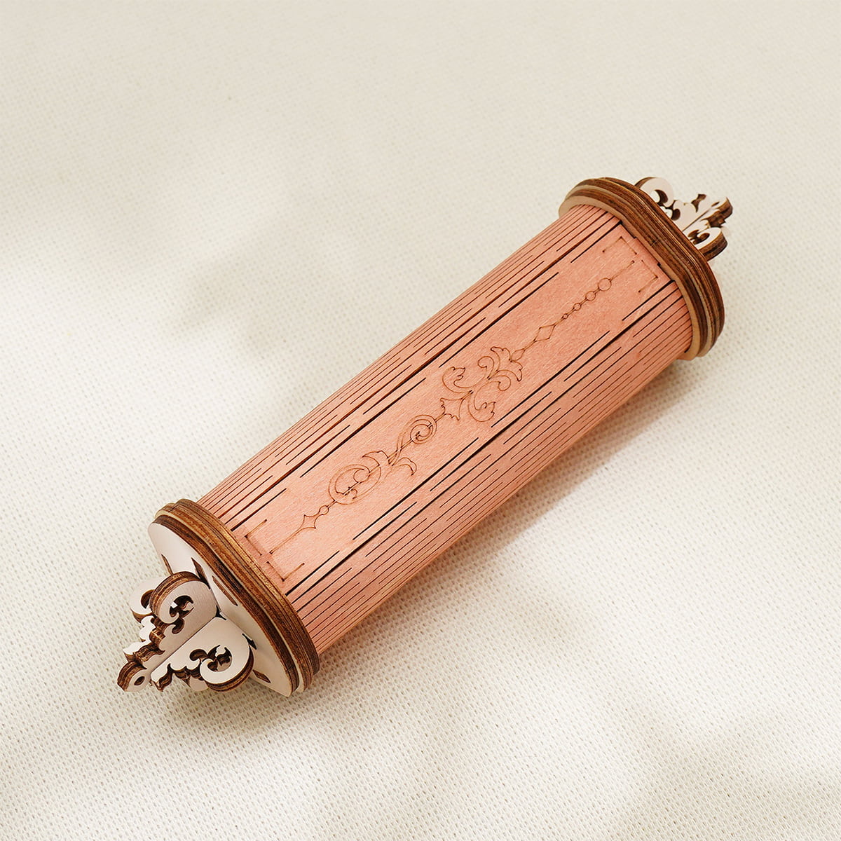 Cylindrical music scroll mechanism of the ROKR Romantic Note Wall Clock, a peach-toned wooden cylinder with ornate decorative end caps
