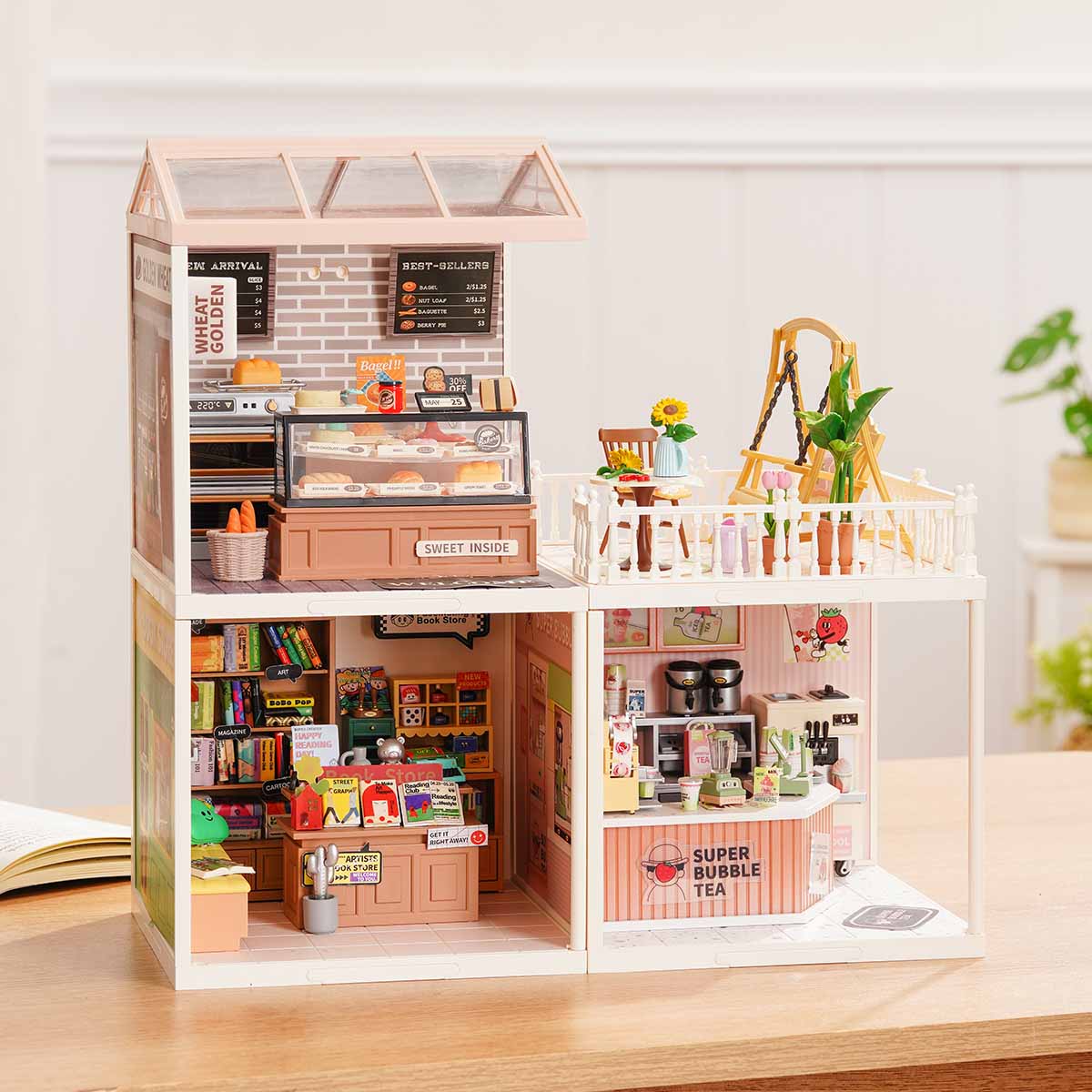 Rolife Super Creator Series 3-in-1 L Shape miniature with a bedroom plus swing rooftop terrace beside a lower kitchen and living room in an L arrangement on a wooden table.