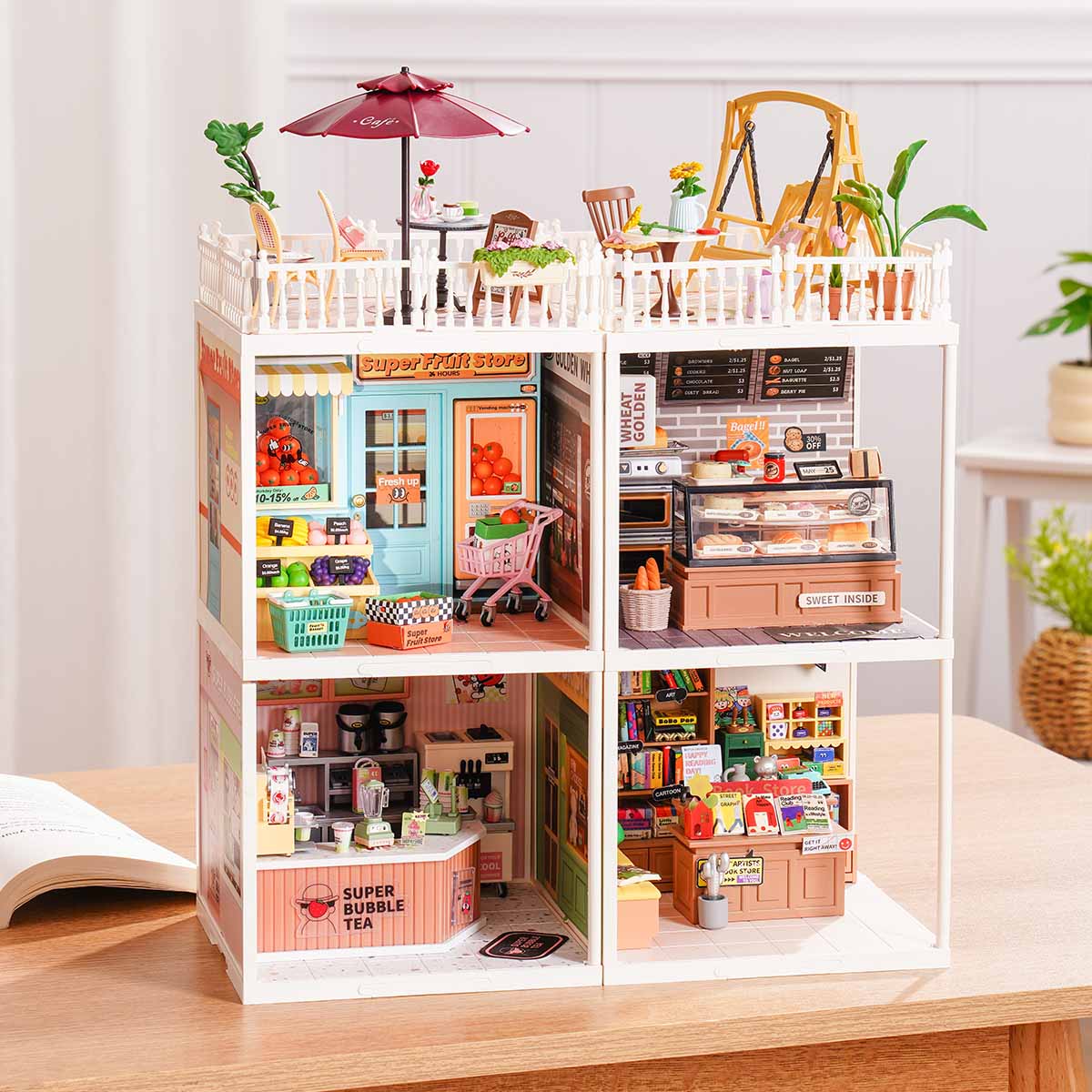 Rolife Super Creator Series 4-in-1 Four Grid miniature with cafe terrace and swing balcony over four rooms including super fruit store, golden bakery, bubble tea shop, and book store.
